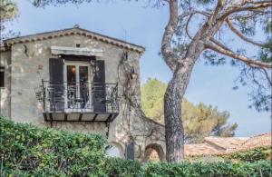 a stone house with a balcony and a tree at Cap d’Antibes Sea view villa in Antibes