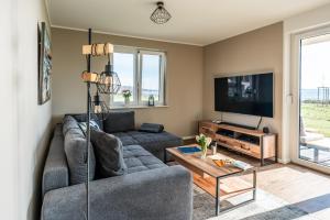ein Wohnzimmer mit einem Sofa und einem TV in der Unterkunft Hangar 19 Luxusbungalow am See H8 in Schwerin