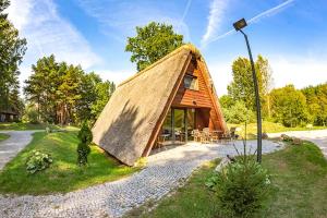 ZawadyCentrum Szkoleniowo-Wypoczynkowe Słoneczny Brzeg的田野上茅草屋顶的小房子