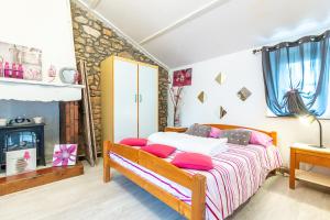 1 dormitorio con cama con almohadas rosas y chimenea en New - Gite Lylou piscine et spa, en Saint-Jean-de-Monts