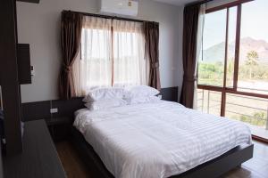 a bed in a room with a large window at dham villa ธาม วิลล่า in Ban Pha Saeng Lang +19 photos