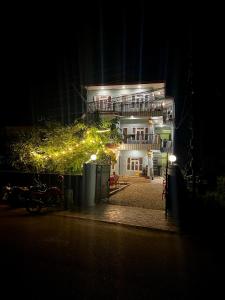 un edificio iluminado por la noche con luces en Paris Guest House Airport, en Bharatpur