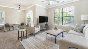a living room with a couch and a tv at Landing at Crescent Park Commons - 1 Bedroom in Greer in Greer