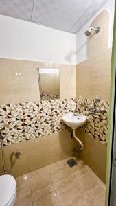 bagno con lavandino e specchio di Paris Guest House Airport a Bharatpur