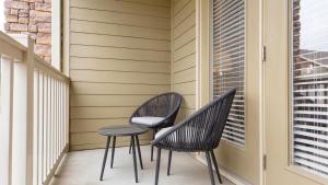 two chairs and a table on a balcony at Landing at The Sovereign at Overland Park Apartments - 1 Bedroom in St. Andrews Highlands in Overland Park