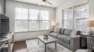 a living room with a couch and a tv at Landing at Three Rivers - 1 Bedroom in Central Fort Wayne in Fort Wayne