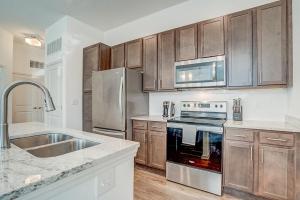 a kitchen with stainless steel appliances and wooden cabinets at Landing at San Marco Promenade - 1 Bedroom in San Marco in Jacksonville