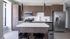 a kitchen with stainless steel appliances and a counter with stools at Landing at The 600 - 2 Bedrooms in Fountain Heights in Birmingham