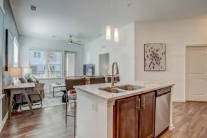 a kitchen with a sink and a living room at Landing at San Marco Promenade - 1 Bedroom in San Marco in Jacksonville