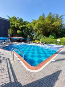 a large swimming pool with blue water at Hotel Campestre la Vega Inn in La Vega