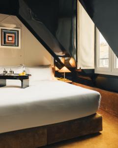 1 dormitorio con cama blanca y mesa en Hôtel Château d'Eau, en París