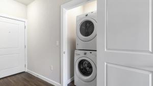 a white laundry room with a washer and dryer at Landing at Mission Hill - 1 Bedroom in New Braunfels in New Braunfels