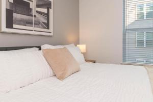 un letto bianco in una stanza con finestra di Landing at San Marco Promenade - 1 Bedroom in San Marco a Jacksonville