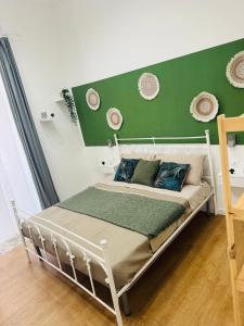 un letto in una camera con parete verde di San marco 56 a Bari