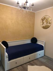 sypialnia z łóżkiem z niebieską pościelą i żyrandolem w obiekcie Helia Apartment w mieście Gałacz