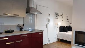 a kitchen with red cabinets and a bed in a room at Les toits de Lascaux in Montignac