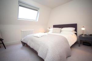 a bedroom with a large bed and a window at Stylish Wood Street Apartment in Bath