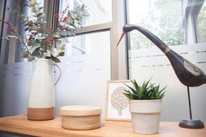 a desk with a plant and a statue on it at Stylish Wood Street Apartment in Bath