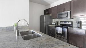 a kitchen with a sink and stainless steel appliances at Landing at Mission Hill - 1 Bedroom in New Braunfels in New Braunfels
