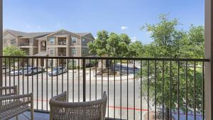 a balcony with two chairs and a building at Landing at Mission Hill - 1 Bedroom in New Braunfels in New Braunfels