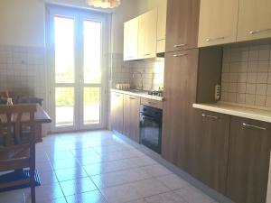 una cucina con mobili in legno, un tavolo e una finestra di Grand Combin ad Aosta