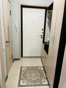 un pasillo con una puerta blanca y una alfombra en el suelo en 2 комнатная за Хан шатыром левый берег en Taldykolʼ