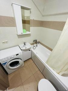a bathroom with a sink and a washing machine at 2 комнатная за Хан шатыром левый берег in Taldykolʼ