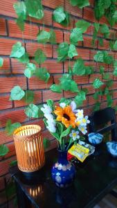une table avec un vase bleu et des fleurs sur elle dans l'établissement Cần Thơ Farmstay, à Cần Thơ