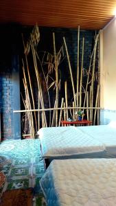 - une chambre avec 2 lits et un mur orné d'une fresque murale dans l'établissement Cần Thơ Farmstay, à Cần Thơ