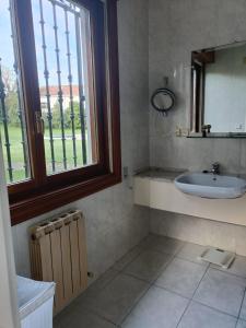 a bathroom with a sink and a window at La Hondonada. in Somo