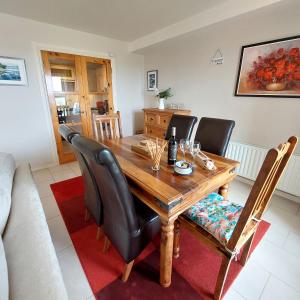 una sala da pranzo con tavolo in legno e sedie nere di Sandy Feet Retreat - Castlerock a Castlerock