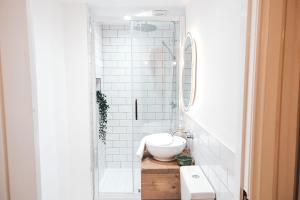 Baño blanco con lavabo y espejo en Pye Corner Cottage, by Solace Stays, en Bellaghy