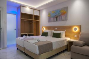 a bedroom with a large bed and a chair at Loutsiana Deluxe Apts in Ayia Napa