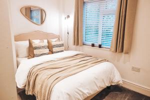 a bedroom with a bed with a mirror and a window at Pye Corner Cottage, by Solace Stays in Bellaghy