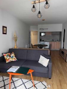 ein Wohnzimmer mit einem Sofa und einem Tisch in der Unterkunft Résidence thermale La Chaldette in Brion