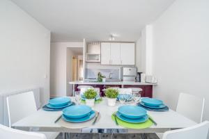 エンプリアブラバにあるApart-rent Apartment Gran Reserva 0057の白いダイニングルーム(青い皿付きのテーブル付)