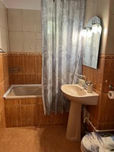 La salle de bains est pourvue d'une baignoire, d'un lavabo et d'une douche. dans l'établissement Apartament Faleza Nord, à Constanţa