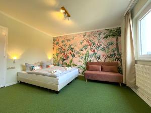 ein kleines Schlafzimmer mit einem Bett und einem Sofa in der Unterkunft WannerHus Hotel in Grömitz