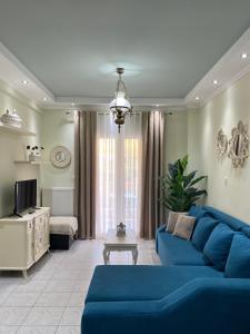 sala de estar con sofá azul y TV en Olivia - Christine's House, en Afitos