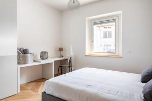 een witte slaapkamer met een bed en een raam bij Residence Moretti Piano Terra in Udine