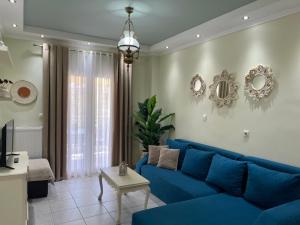 - un salon avec un canapé bleu et une table dans l'établissement Olivia - Christine's House, à Afytos