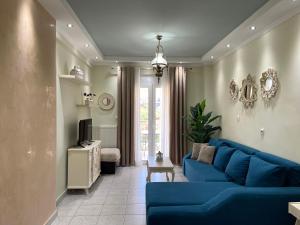 un soggiorno con divano blu e TV di Olivia - Christine's House ad Áfitos