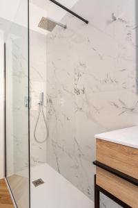 baño con ducha de mármol blanco en Residence Moretti Piano Terra en Udine