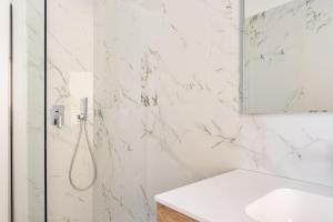 een witte badkamer met een douche en een wastafel bij Residence Moretti Piano Terra in Udine