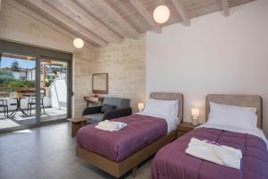 een slaapkamer met 2 bedden en een stoel en een balkon bij Sun Flower Villas in Agia Marina Nea Kydonias +81 foto's
