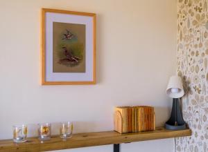 a shelf with glasses and a picture on a wall at Daisy Bank Camp in Hebden Bridge