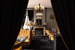 een eetkamer met tafels en stoelen en een kroonluchter bij Domaine du Chesney in Pressagny l'Orgueilleux