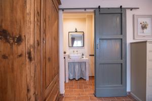 La salle de bains est pourvue d'une porte bleue et d'un lavabo. dans l'établissement Podere Cornacchino, à Peccioli