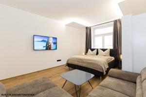 INNSBRUCK CENTER APARTMENTS tirol في إنسبروك: غرفة معيشة مع سرير وأريكة