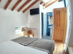 1 dormitorio con 1 cama y 1 silla y baño en 6 bedrooms house with furnished garden and wifi at Otanes 4 km away from the beach, en Otañes